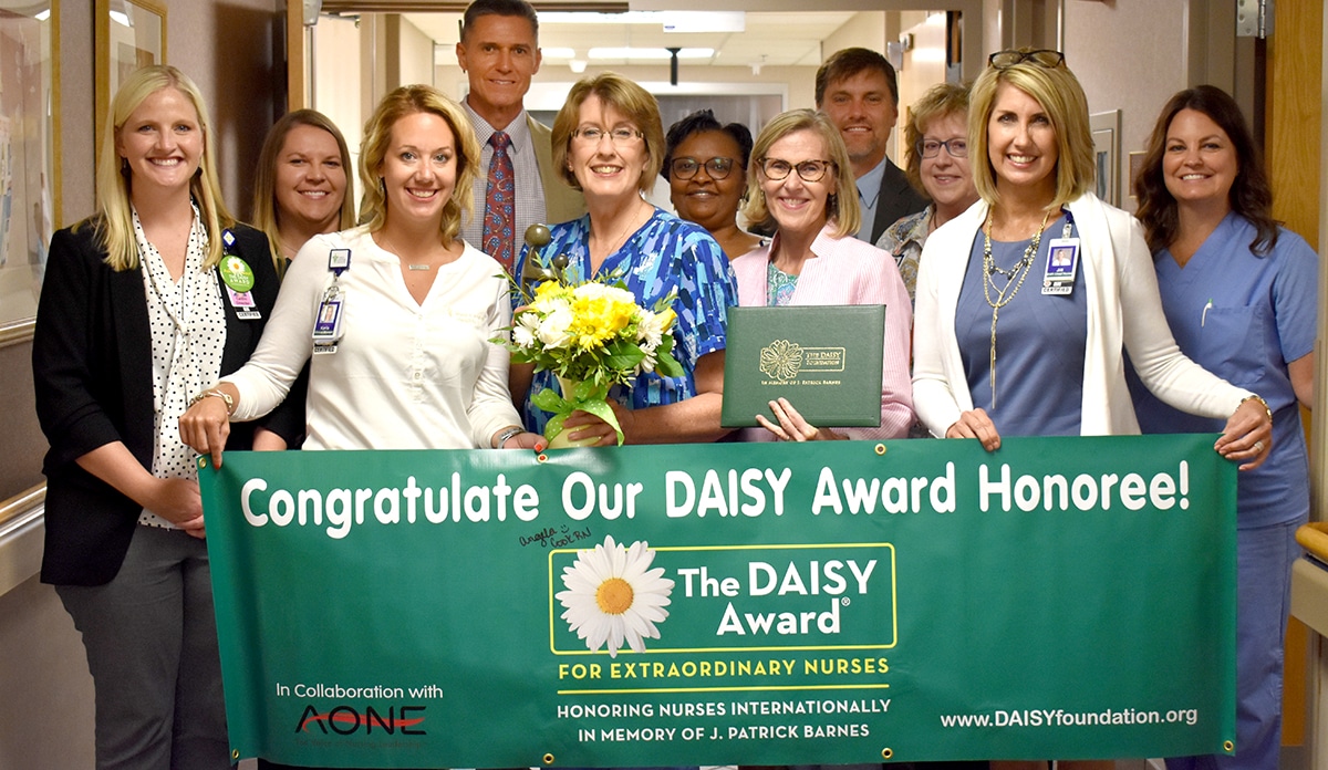 Med Center Health executives and staff congratulate Daisy Award winner Beth Williams.