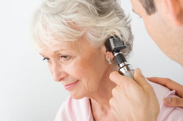 Woman having her ear examined.