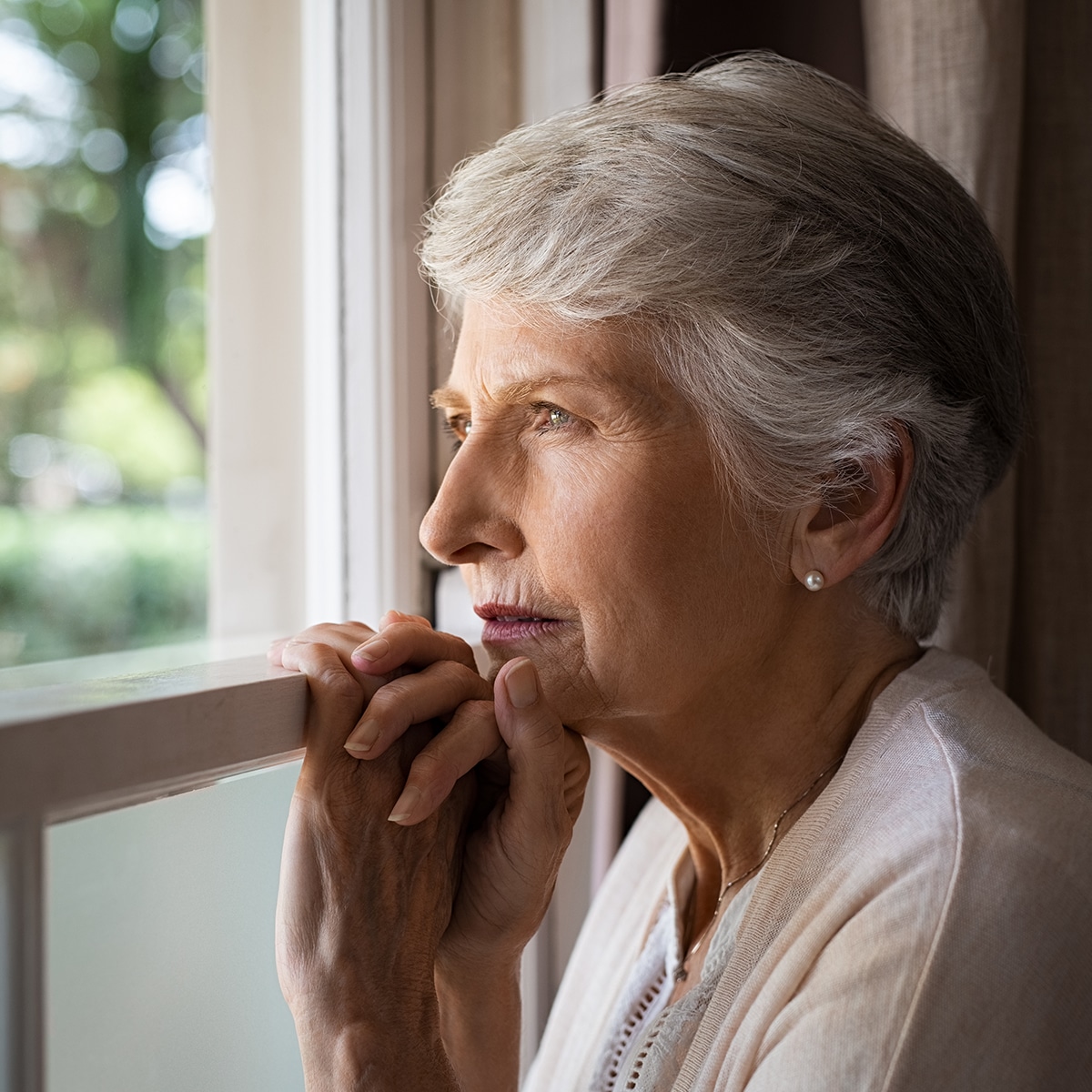 Older woman gazing out a window
